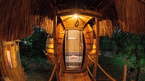 Une structure en bois dotée d’un espace d’observation vitré, entourée d’une végétation naturelle.