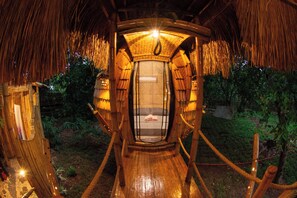 Une structure en bois dotée d’un espace d’observation vitré, entourée d’une végétation naturelle.