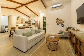 Ein modernes Wohnzimmer mit einer Couch, einem Couchtisch und einer Küche im Hintergrund.
