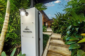 A sign for 'Volcancito' with a staircase leading to a covered area surrounded by lush tropical plants. - Casa Volcancito- Volcan View (Provincia de Alajuela)