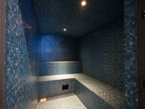 A tiled bathroom with a bench and a small window. - 2 bedroom beachfront in Nyali with infinity pool, sauna, gym & near malls (Mombasa)