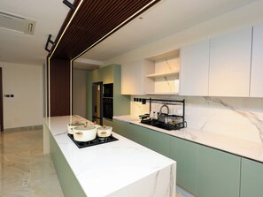 A modern kitchen with a marble countertop, built-in appliances, and a black dish rack. - 2 bedroom beachfront in Nyali with infinity pool, sauna, gym & near malls (Mombasa)