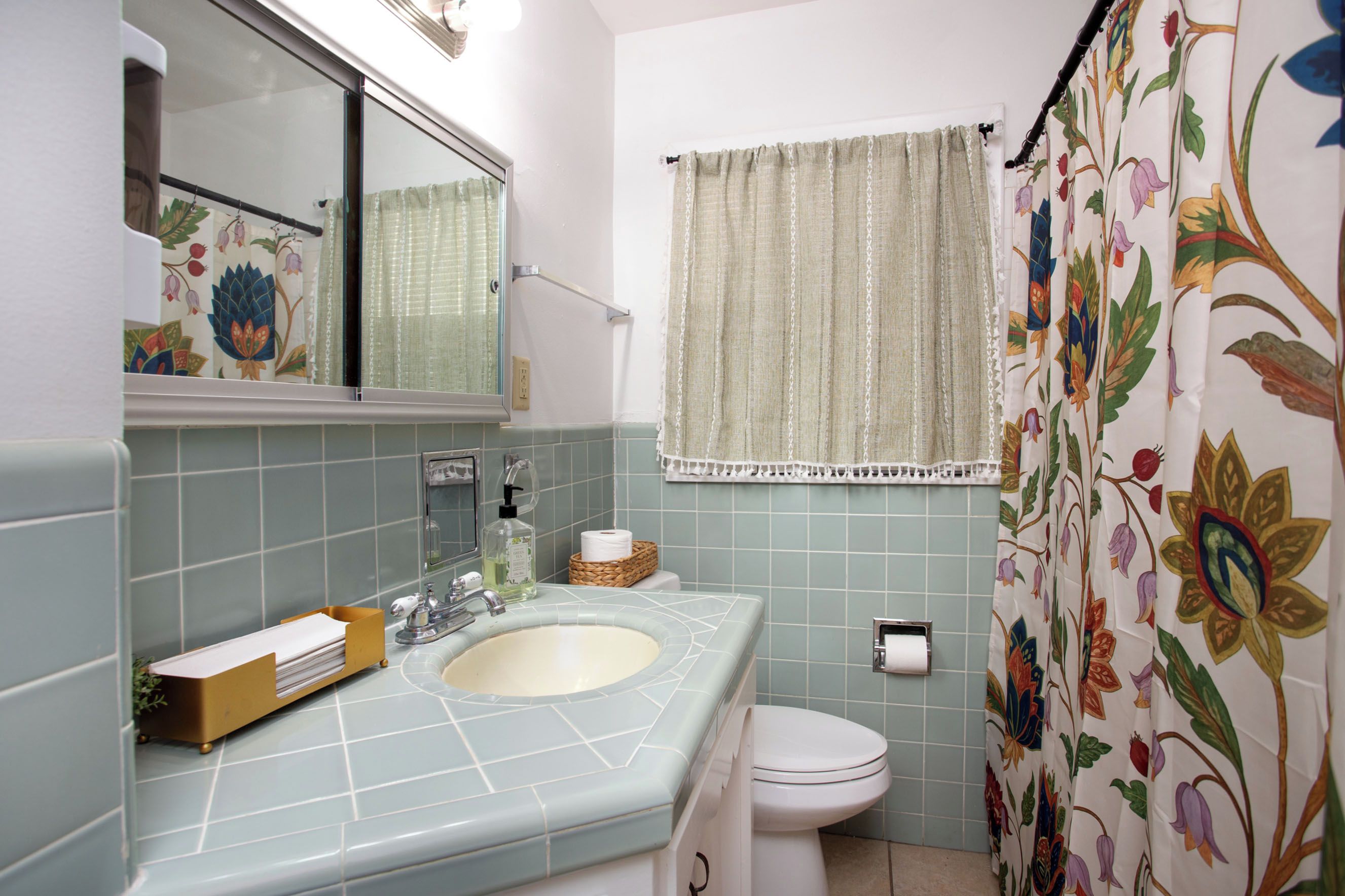 Un baño con lavamanos, inodoro y cortina de ducha.