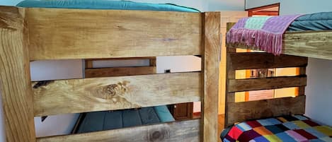 A bunk bed with a wooden headboard and a colorful quilt.