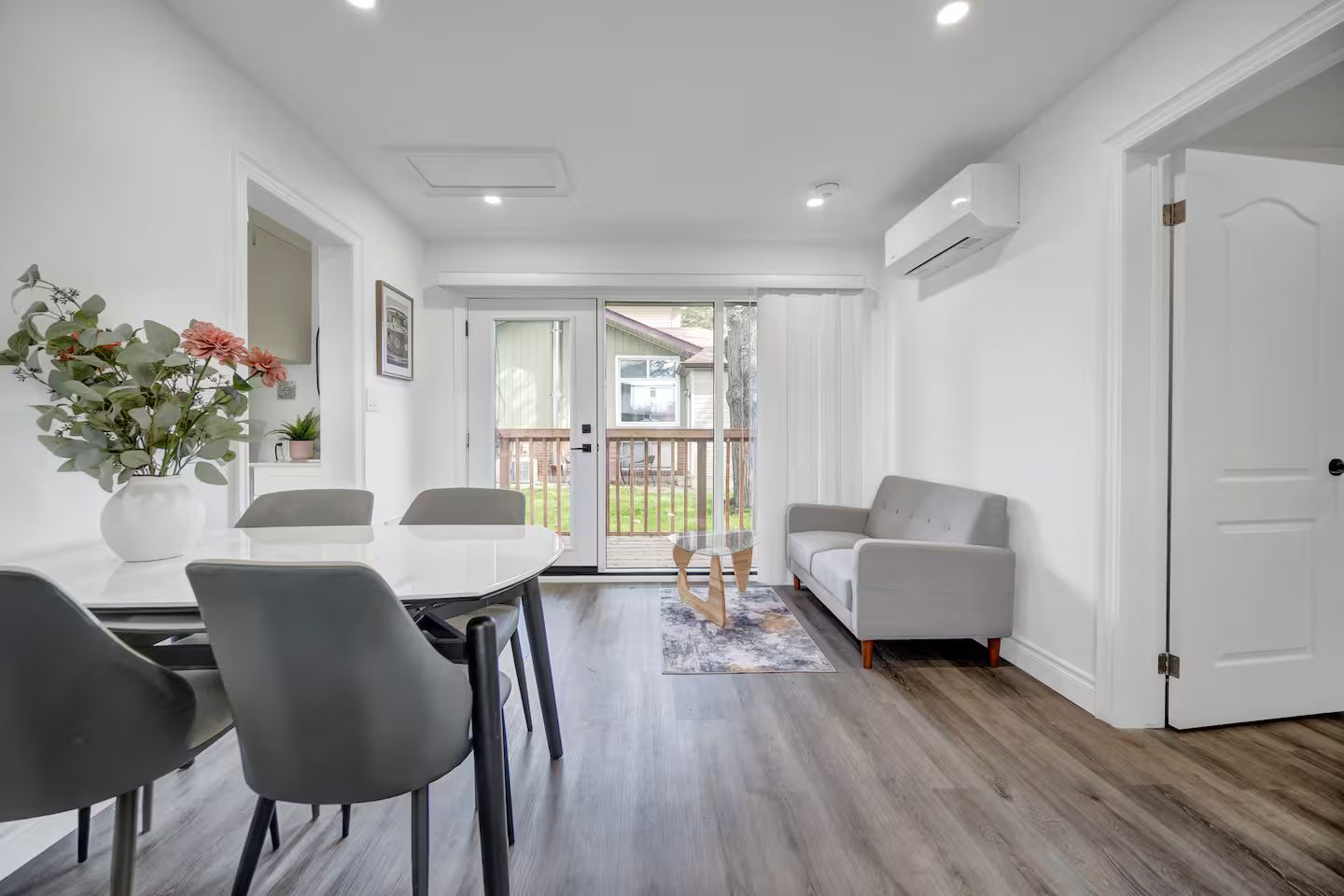 A modern living room with a dining area, a sofa, and a coffee table.