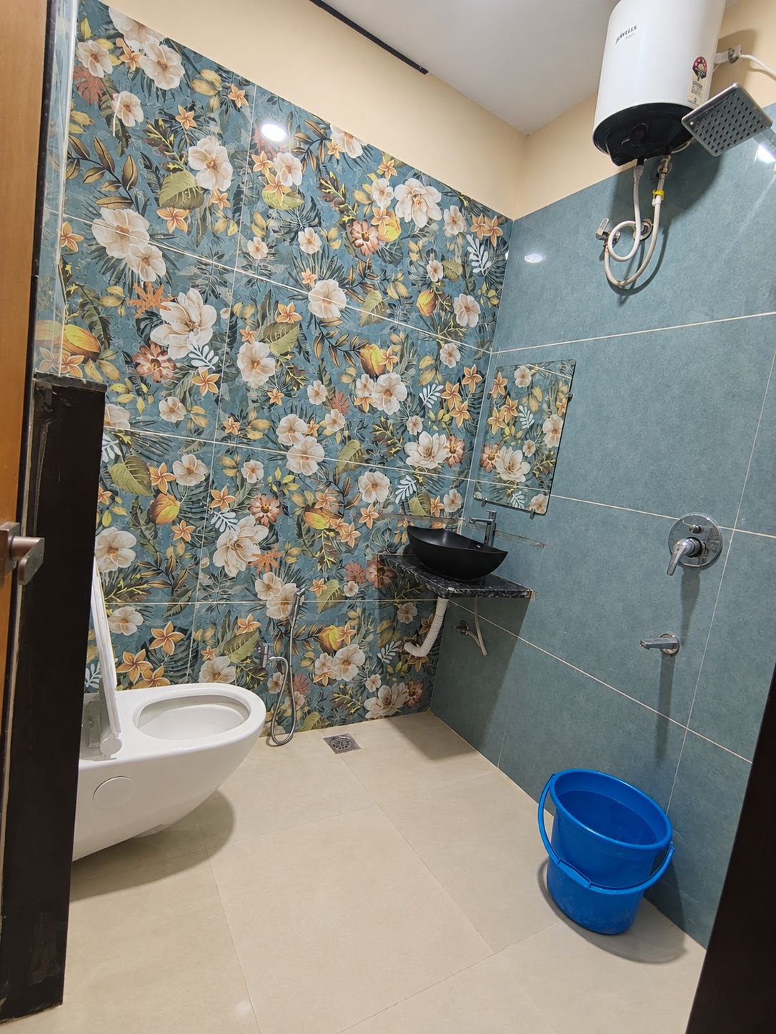 Ein Badezimmer mit Toilette, Waschbecken, Dusche und einem blauen Eimer.