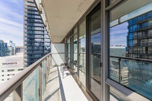 Een balkon met uitzicht op een stadsgezicht, waaronder een gebouw met de aanduiding 'WOMEN'S'.