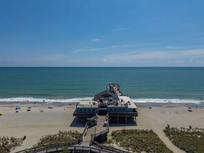 A beach with a pier extending into the ocean, a sandy beach, and a clear sky. - Myrtle Beach Oceanfront Escape at Yachtsman S1004 (Myrtle Beach)