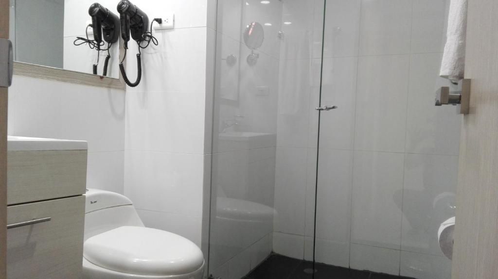 A bathroom with a toilet, a sink, and a glass-enclosed shower area.