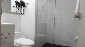 A bathroom with a toilet, a sink, and a glass-enclosed shower area.