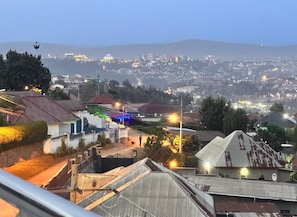 Zona residencial con casas, una calle y una vista distante de un paisaje urbano con una estructura en forma de cúpula.