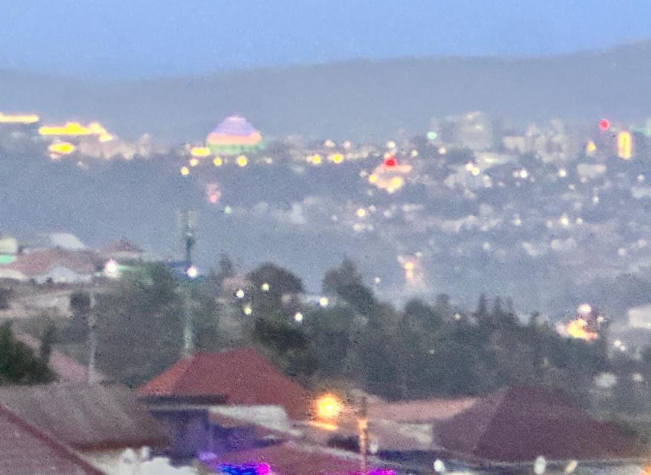 A cityscape with buildings and a distant dome structure.
