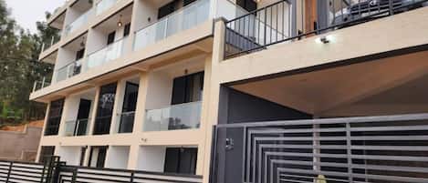 A multi-story residential building with balconies, a gated entrance, and a modern architectural design.