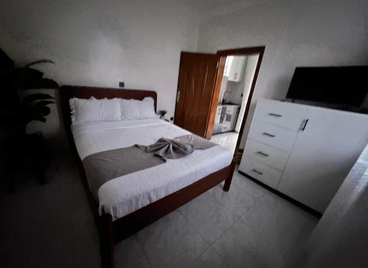 A bedroom with a bed, a wardrobe, and a desk.