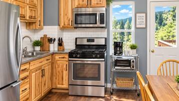 Une cuisine moderne avec des meubles en bois, des appareils en acier inoxydable et une vue sur l’extérieur.