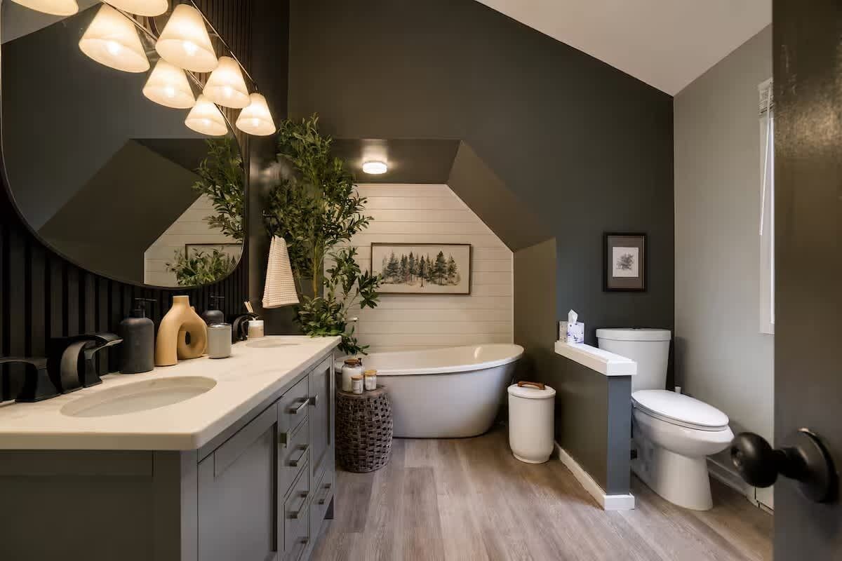 Een moderne badkamer met een vrijstaand bad, een toilet en een wastafel.