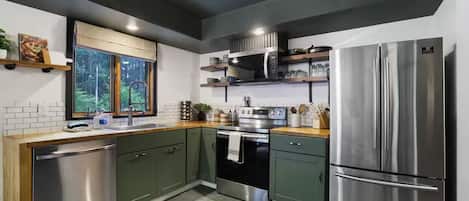 Una cocina moderna equipada con lavavajillas, horno, microondas y refrigerador.
