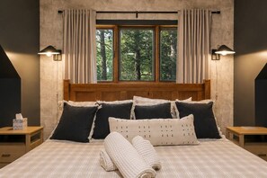 A bed with a wooden headboard, multiple pillows, a bedside table with a tissue box, and a window with curtains. - Pine & Peace Retreat | Hot Tub | Fire Pit (Blakeslee)