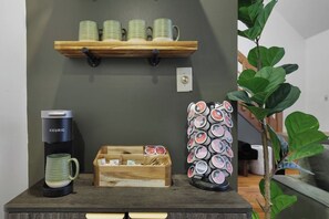 A coffee station with a Keurig machine, a wooden mug holder, and a decorative mug with a pattern. - Pine & Peace Retreat | Hot Tub | Fire Pit (Blakeslee)