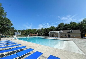 A swimming pool with blue lounge chairs, a lifeguard stand, and a covered pavilion. - Putting Green | Hot Tub | Sauna | Theater | Arcade (Coolbaugh Township)
