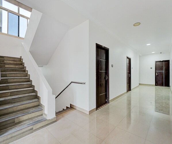 Un interior moderno con una escalera, una puerta y un pasillo.