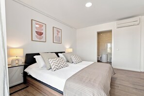 A modern bedroom with a bed, bedside tables, and a nightstand. - Two-Bedroom Apartment with Pool and Balcony in Albufeira, Algarve (Albufeira)