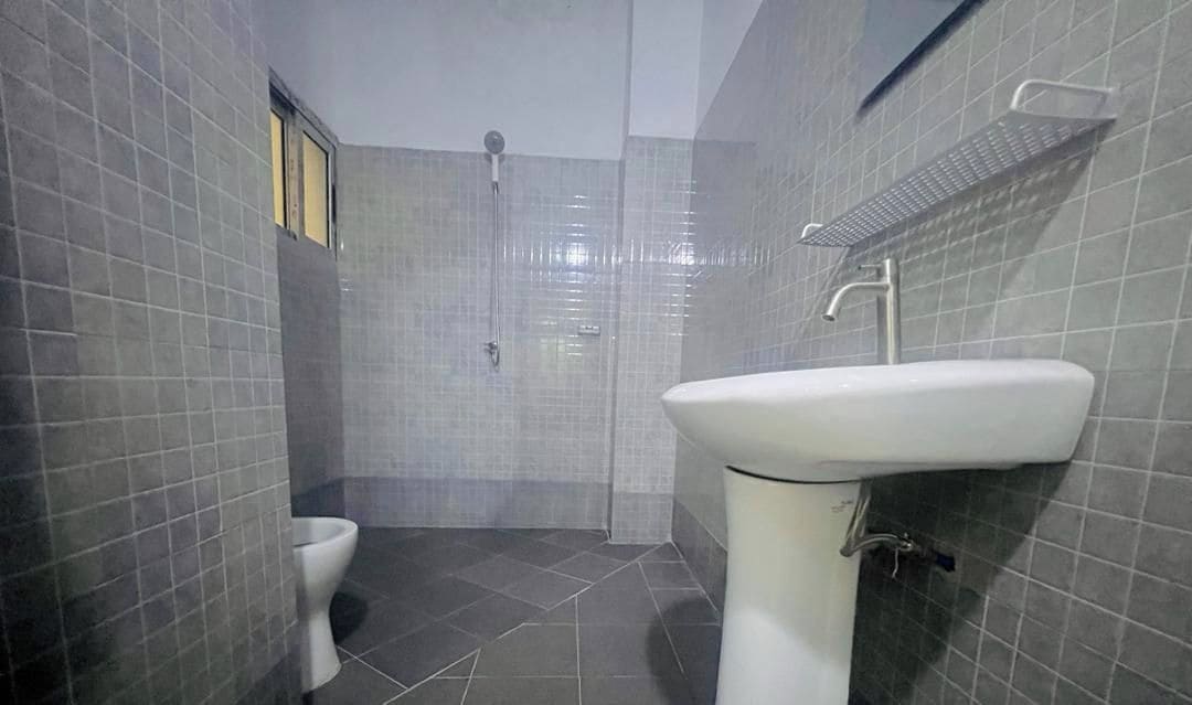 Een badkamer met toilet, wastafel en douche.