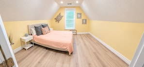 Une chambre à coucher avec un lit, une table de chevet et des éléments décoratifs sur les murs.