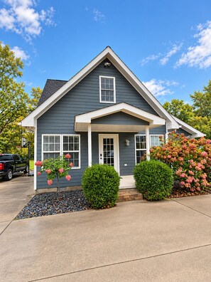 A two-story house with a gabled roof, a front porch, and a driveway. - Relaxing 2-bedroom pool house - Bedford, IN. Easy drive for IU Football (Bedford)
