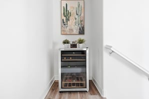A wine refrigerator with a digital display, a cactus painting above it, and a white railing to the right. - #1 Anaheim Gem-Disney-Stadium-Honda Center-Pool-Spa-BBQ-Park (Anaheim)