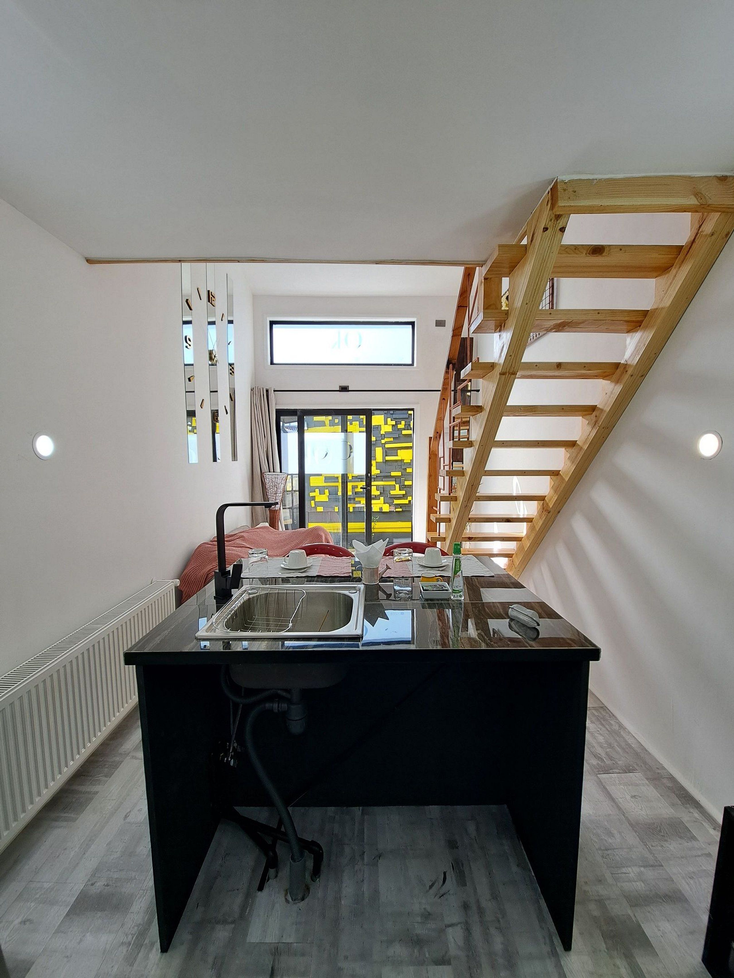 A modern kitchen with a central island, a built-in oven, and a window with a view.