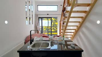 Una cocina moderna con una isla central, horno empotrado y ventana con vistas.