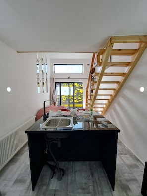 Una cocina moderna con una isla central, horno empotrado y ventana con vistas.