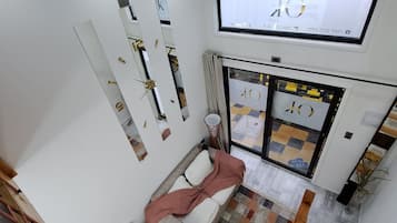 A modern interior with a sofa, a television, and a patterned floor.
