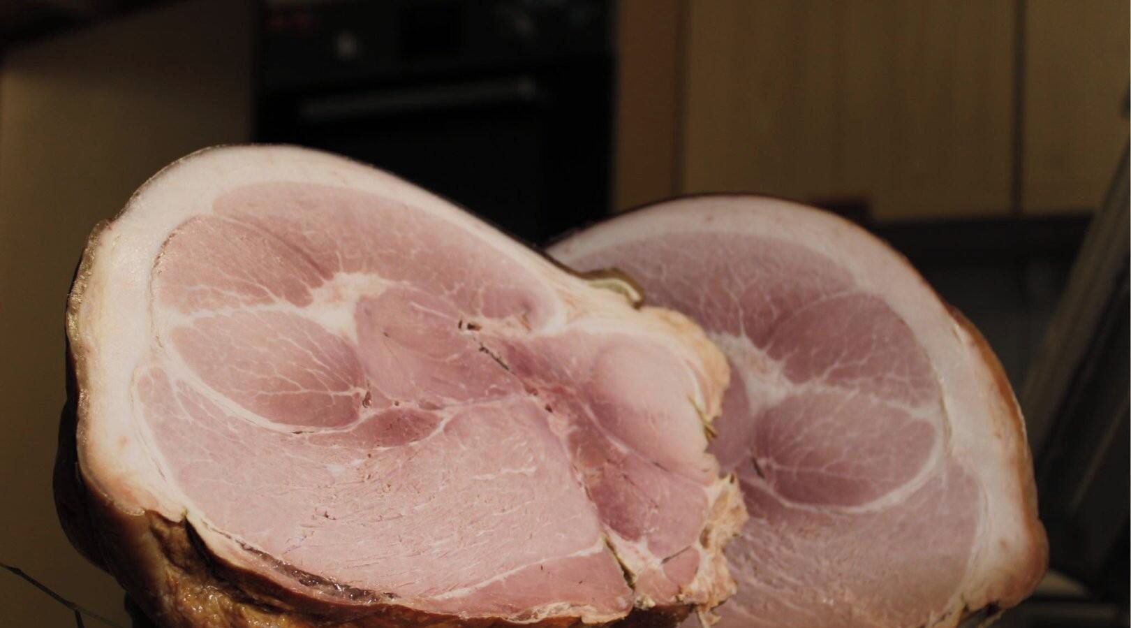 Un gran trozo de carne, posiblemente cerdo, con fibras musculares y capas de grasa visibles.