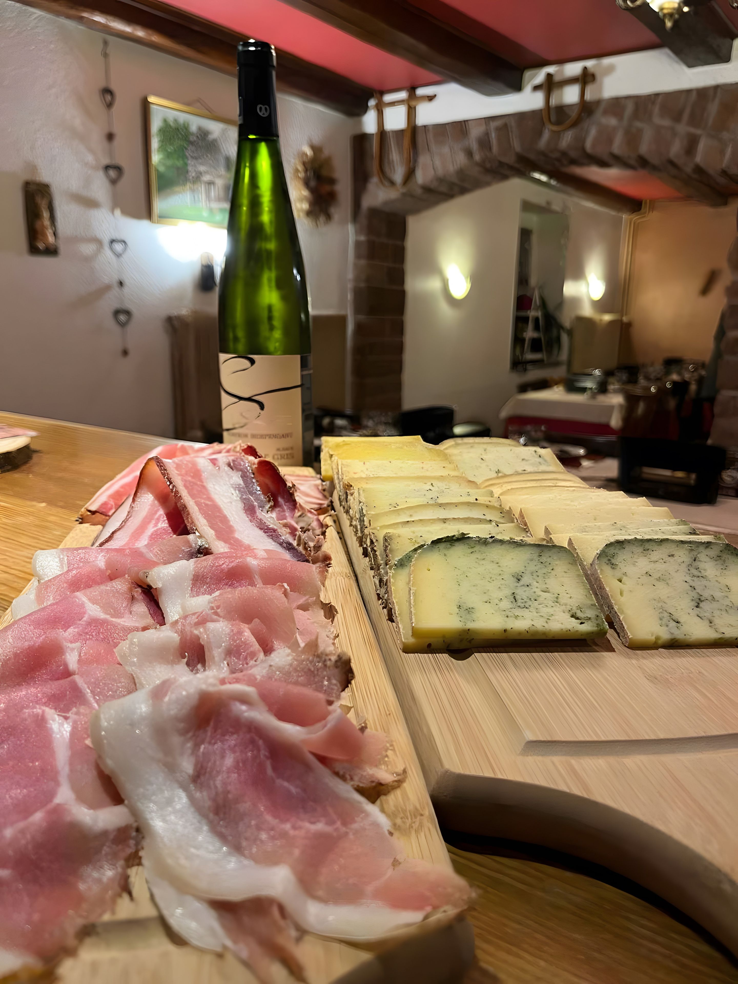 Una tabla de madera con diferentes carnes y quesos.
