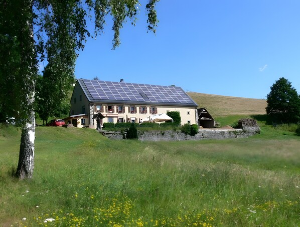 Une maison avec un toit en pente et des panneaux solaires.