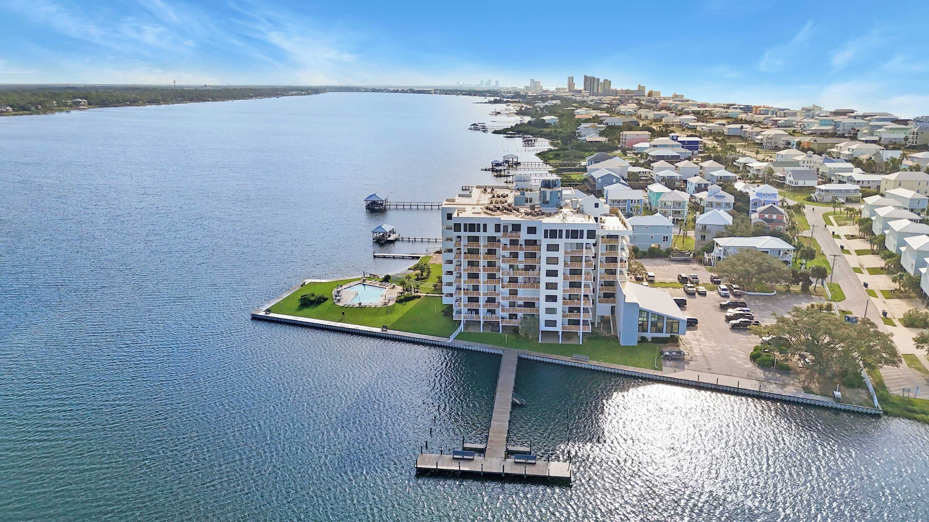 A waterfront property with a multi-story building, a dock, and a marina.