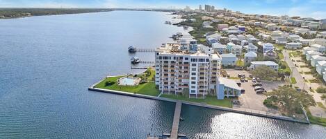 A waterfront property with a multi-story building, a dock, and a marina.