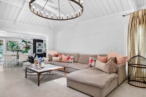 Uma sala de estar moderna com sofá seccional, mesa de centro e luminária pendente.