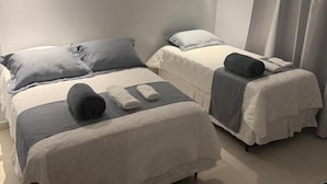A hotel room with two beds, a chair, a desk, and a window with curtains. - UMARI RESERVA HOTEL (Benevides)