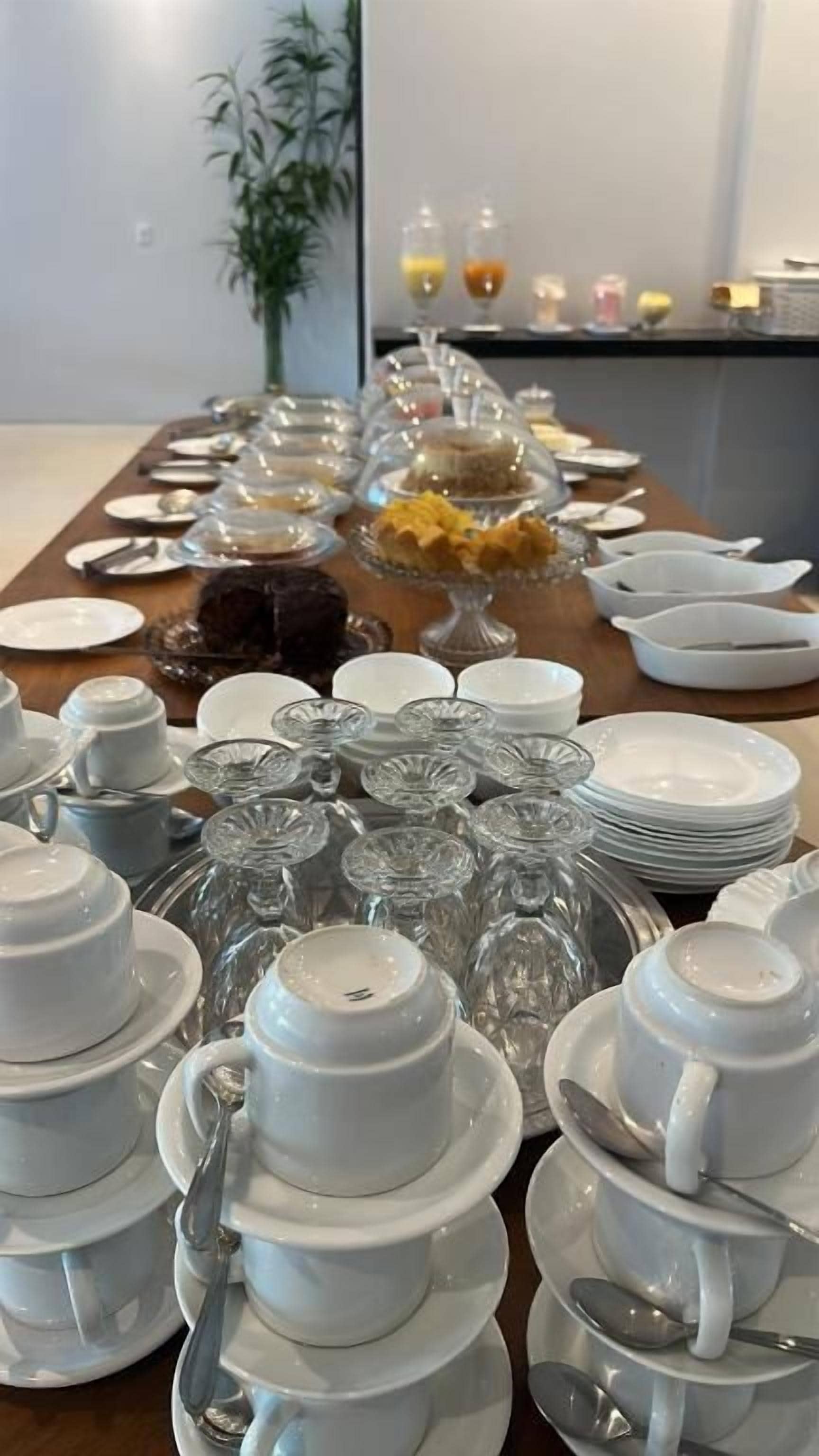 Uma mesa de buffet com diversos pratos e uma variedade de copos e pratos.