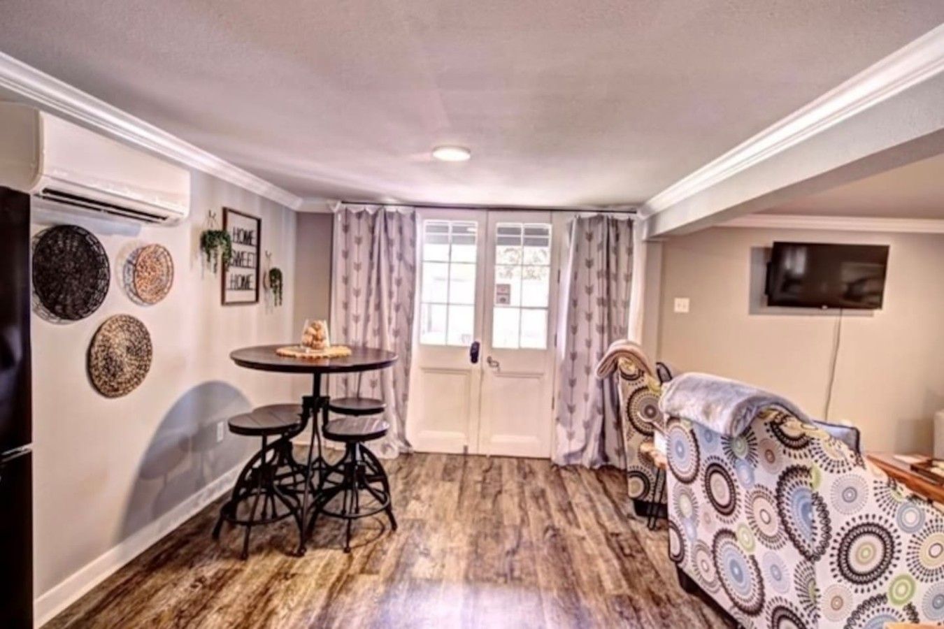 A compact living space with a dining table, a sofa, and a television.