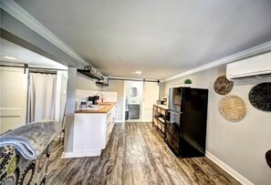 A compact kitchen with a central island, a refrigerator, and a dining area with a table and chairs. - Maison Shea
The Magnolia (Natchitoches)