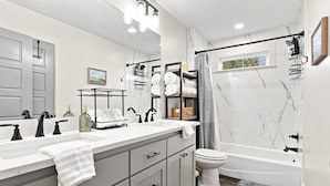 Un bagno moderno con un mobile lavabo doppio, un water e una vasca da bagno.