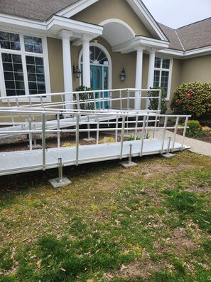 A residential building with a covered porch, a blue door, and a wheelchair-accessible ramp. - Beautiful Waterfront Property, Dock, Handicap Facilities and Wonderful Sunsets (Lancaster)