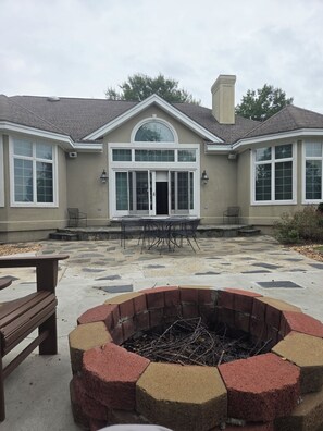 A house with a fire pit, outdoor seating, and a large window. - Beautiful Waterfront Property, Boat Dock, Covered Carport and Wonderful Sunsets (Lancaster)
