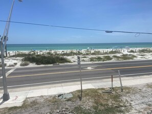 A beach view with a road, beach umbrellas, and a clear sky. - Ocean View! Come Escape with Us! (Bradenton Beach)