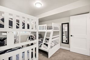 Quarto com beliches, porta e espelho.