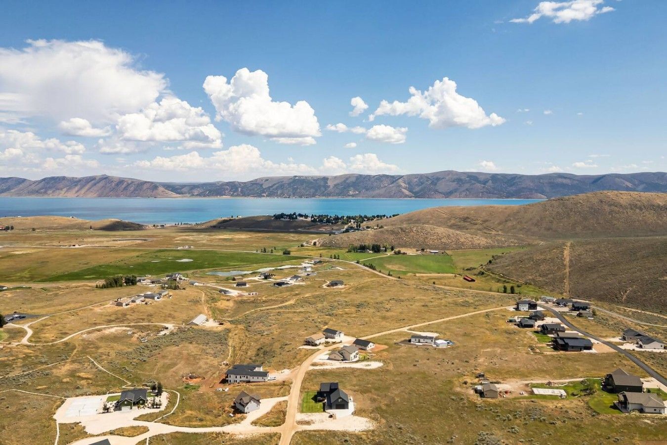 A residential area with houses and a large body of water in the background.